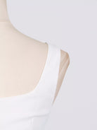 NEWYORKLISTED STYLE COLLECTION: White sleeveless top on a mannequin with a light gray background