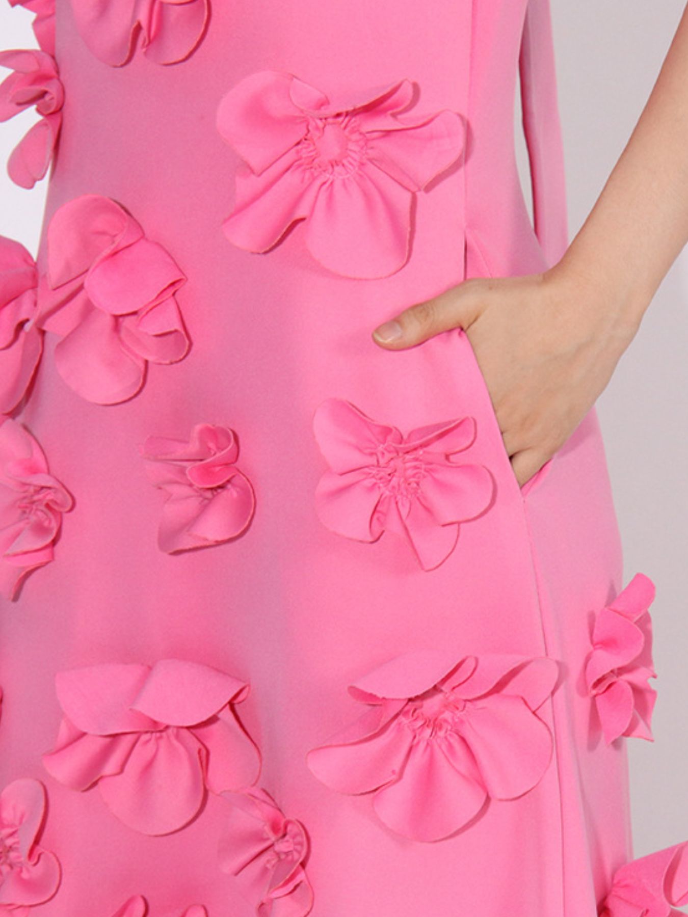 NEWYORKLISTED STYLE COLLECTION: Close-up of a pink dress with floral patterns on a plain background
