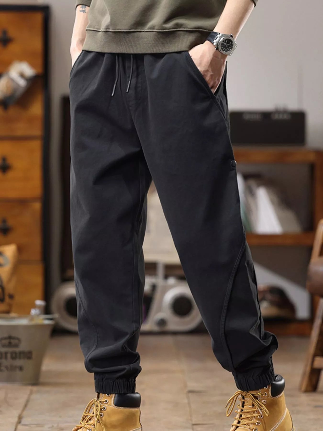 NEWYORKLISTED ATLAS MEN's COLLECTION: Person wearing black jogger pants with a blurred indoor background