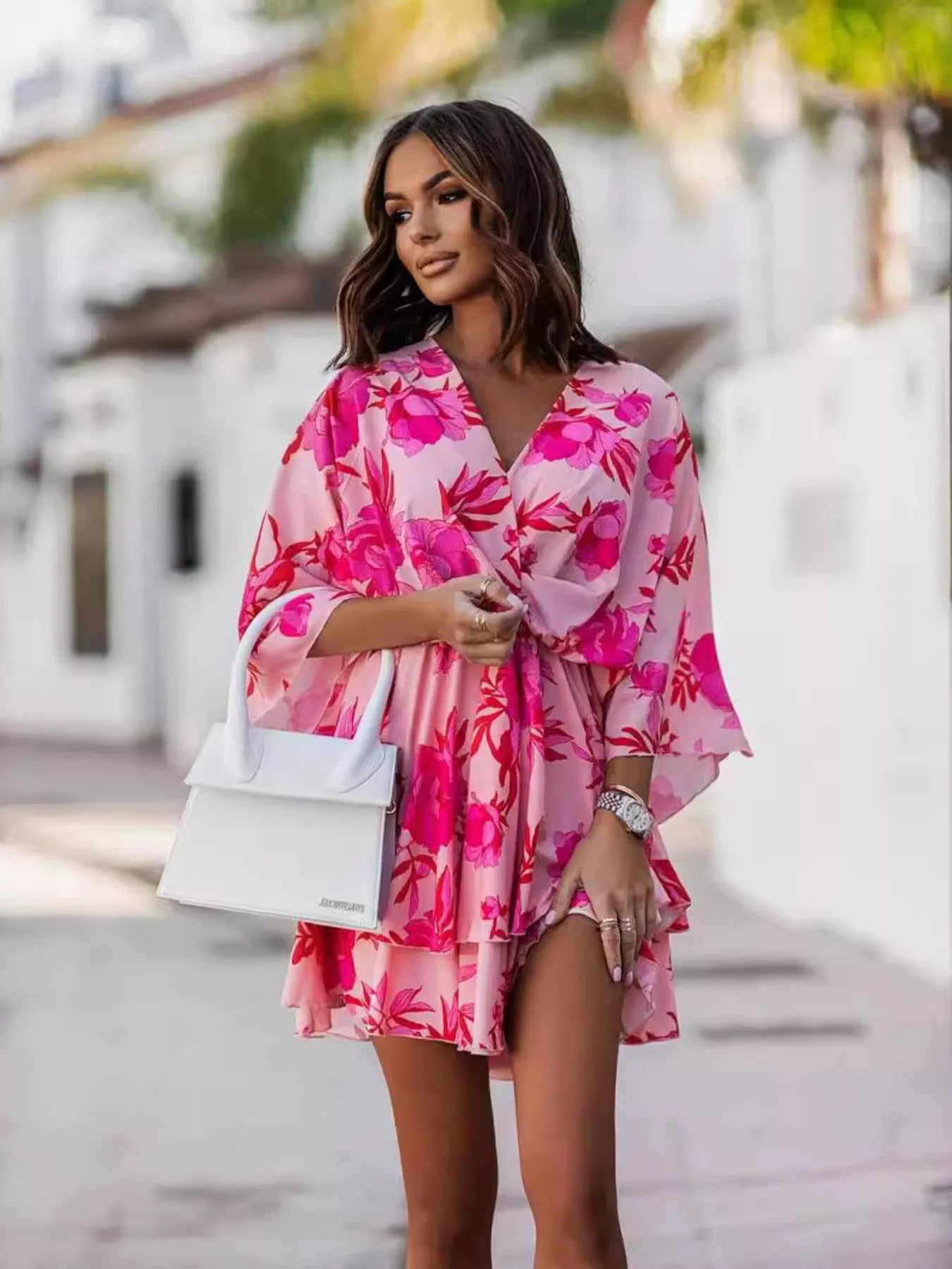 NEWYORKLISTED STYLE COLLECTION: Woman wearing a pink floral dress with a blurred background