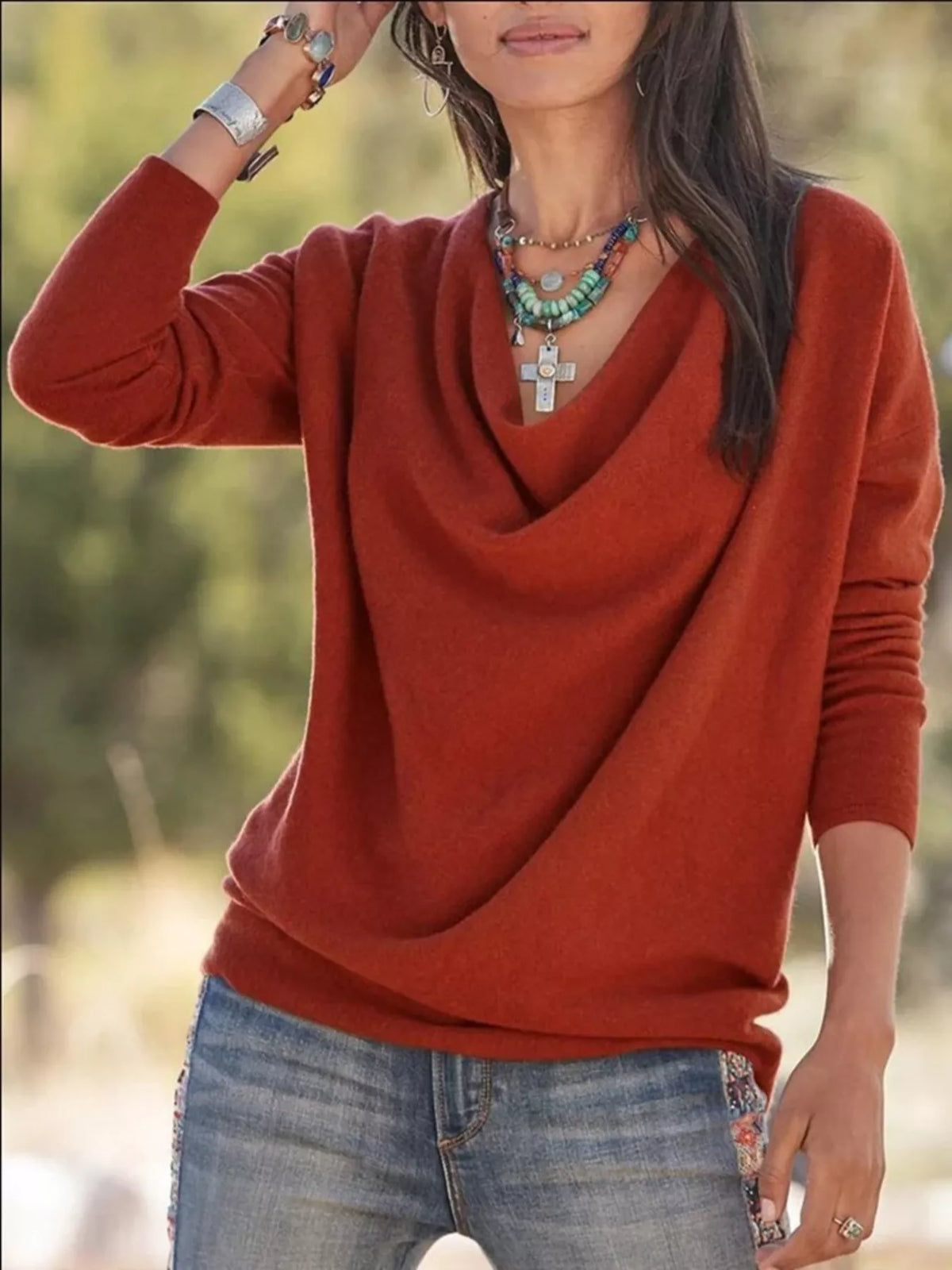 NEWYORKLISTED STYLE COLLECTION: Person wearing a rust-colored sweater and blue jeans with a blurred natural background