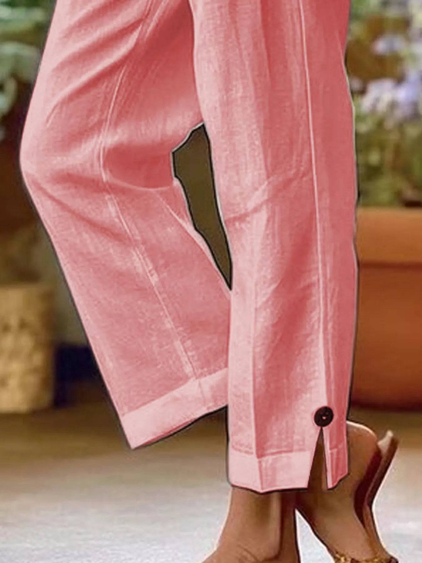 NEWYORKLISTED STYLE COLLECTION: Pink wide-leg trousers shown on a model from the knees down, featuring a split cuff with a single button and a dark olive green accent panel on the upper leg.