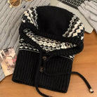 NEWYORKLISTED STYLE COLLECTION: Drawstring Knitted Winter Hat – Cozy, Chic & Cold-Weather Ready: Black and white patterned knitted cowl on a wooden surface with a laptop and magazine in the background.