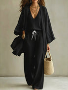 NEWYORKLISTED STYLE COLLECTION: Woman wearing a black outfit with a beige background
