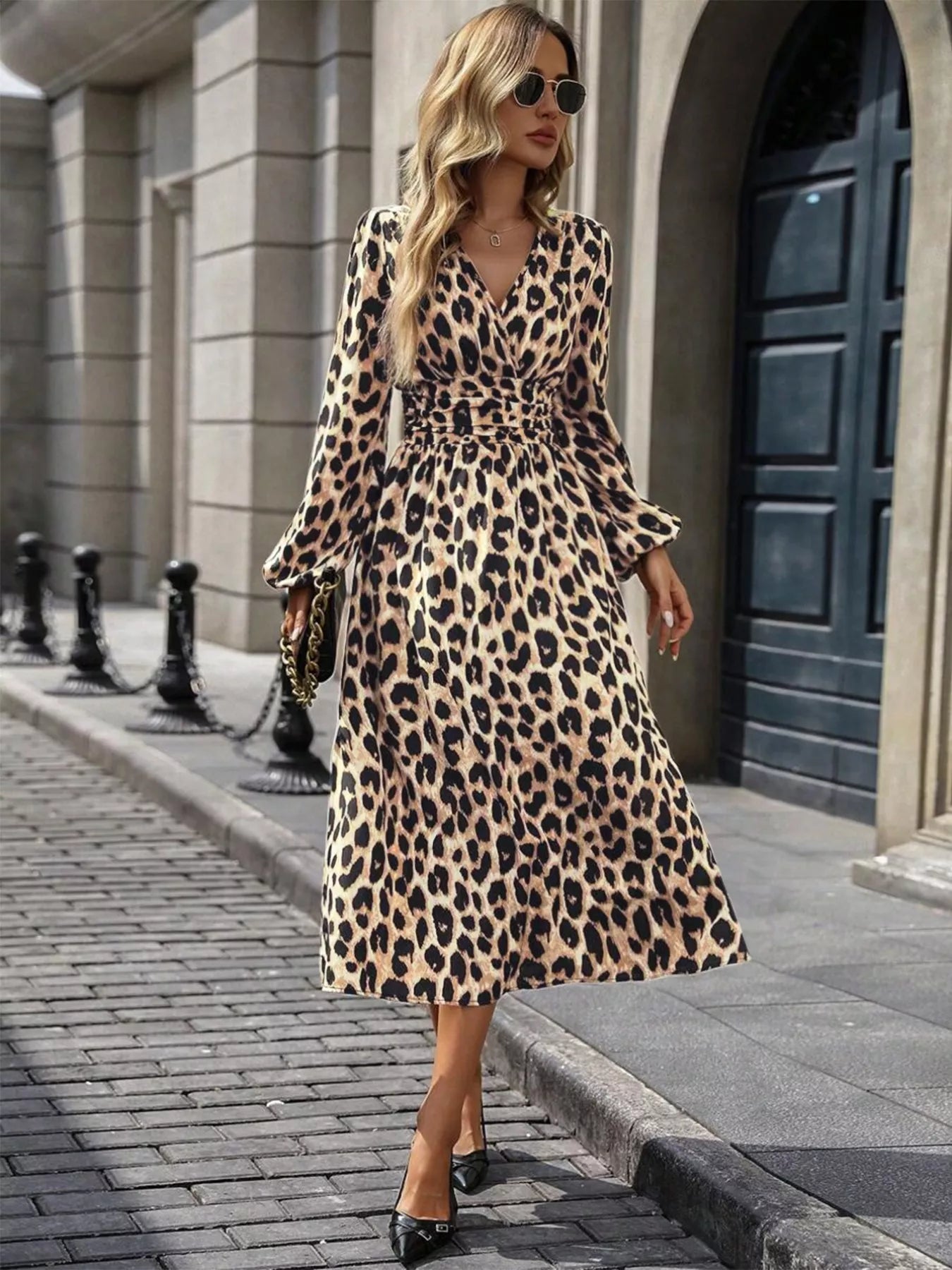 Woman wearing a leopard print dress walking on a city street.