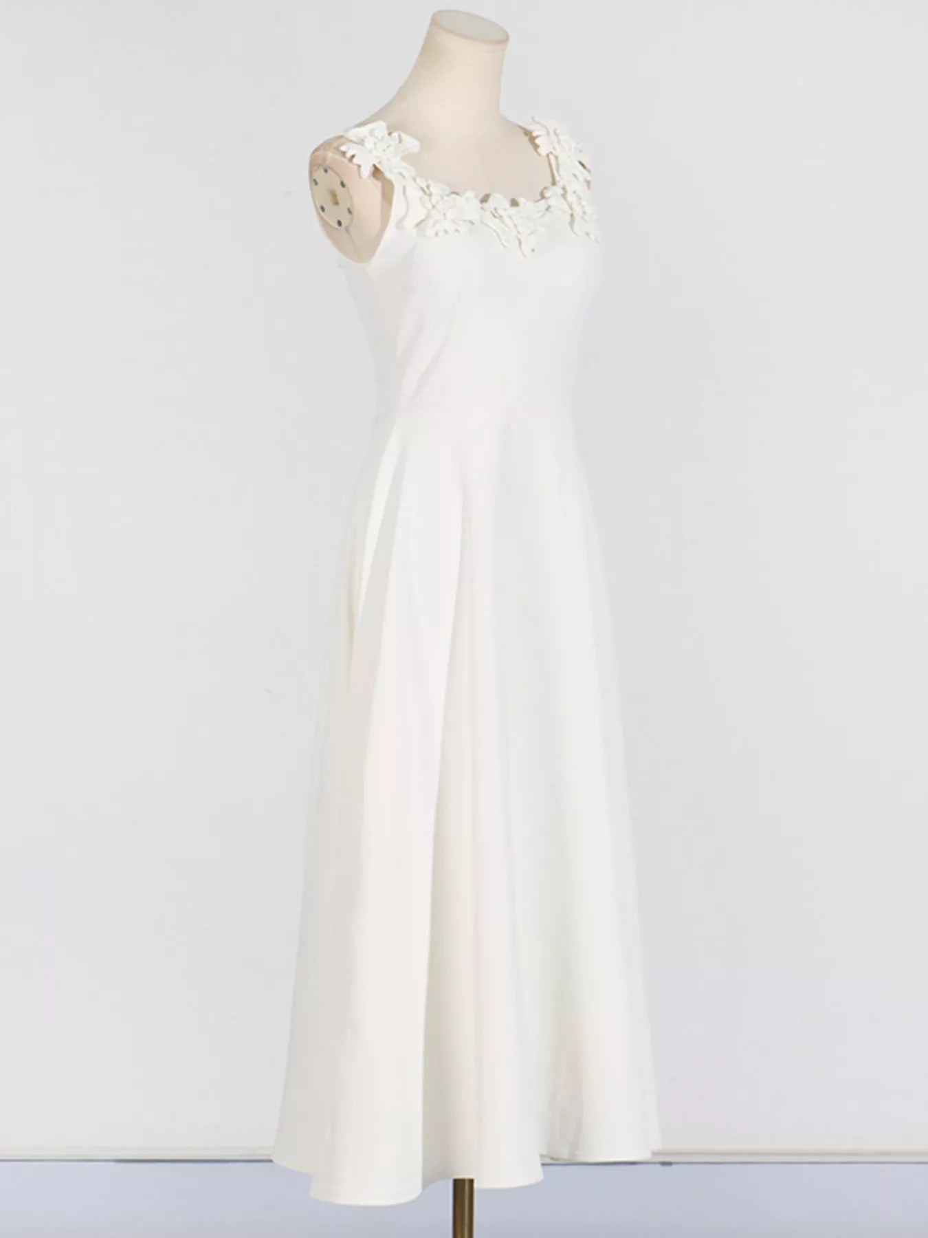 NEWYORKLISTED STYLE COLLECTION: White dress on a mannequin against a plain background
