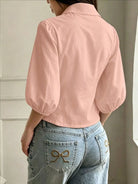 NEWYORKLISTED STYLE COLLECTION: A woman shown from the back wearing a light pink cropped blouse with voluminous elbow-length puff sleeves and light-wash blue jeans with decorative bow embroidery on the back pockets.
