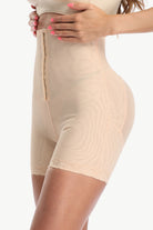 Beige shapewear being worn on a white background