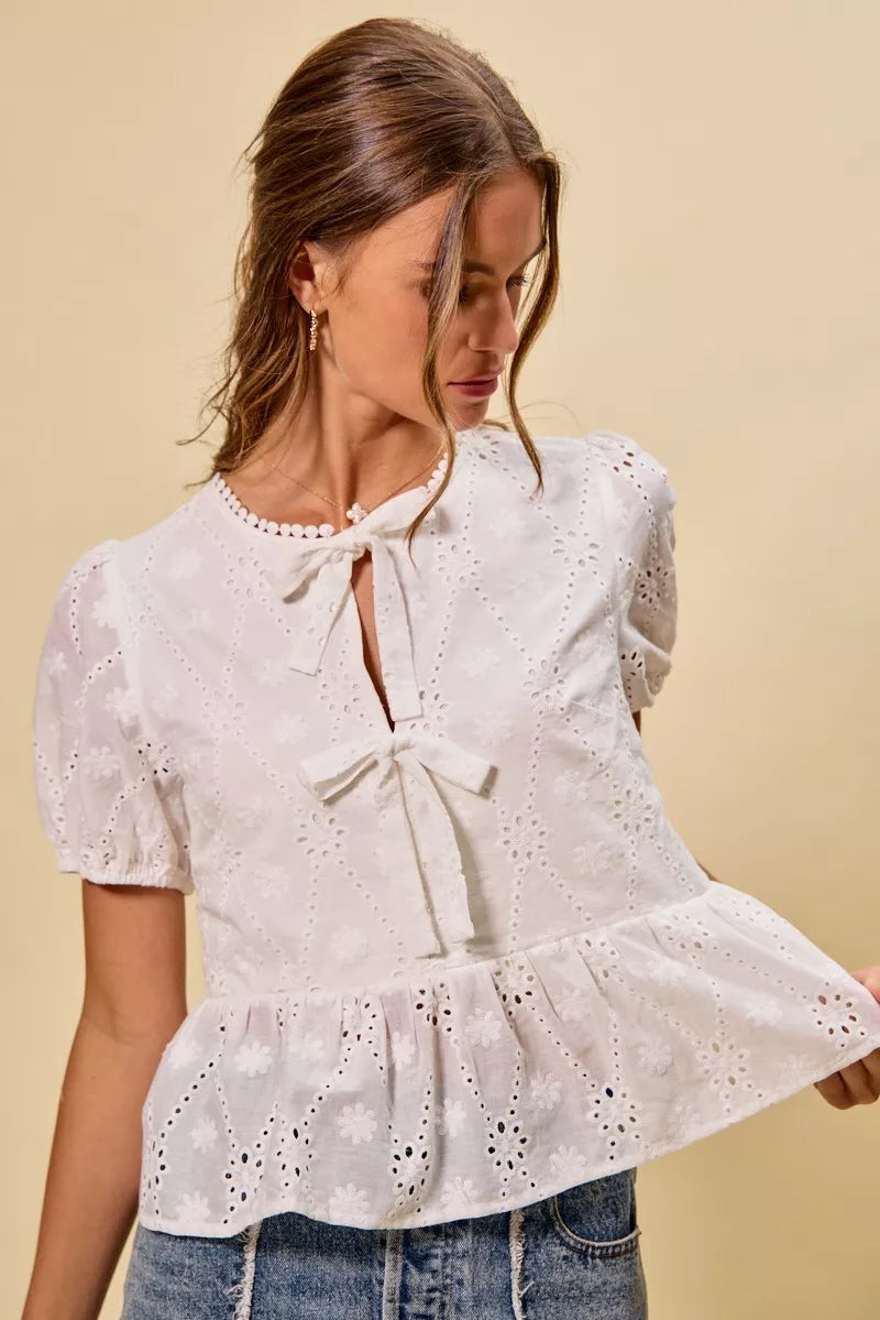 NEWYORKLISTED STYLE COLLECTION:  Woman wearing a white lace blouse with a beige background