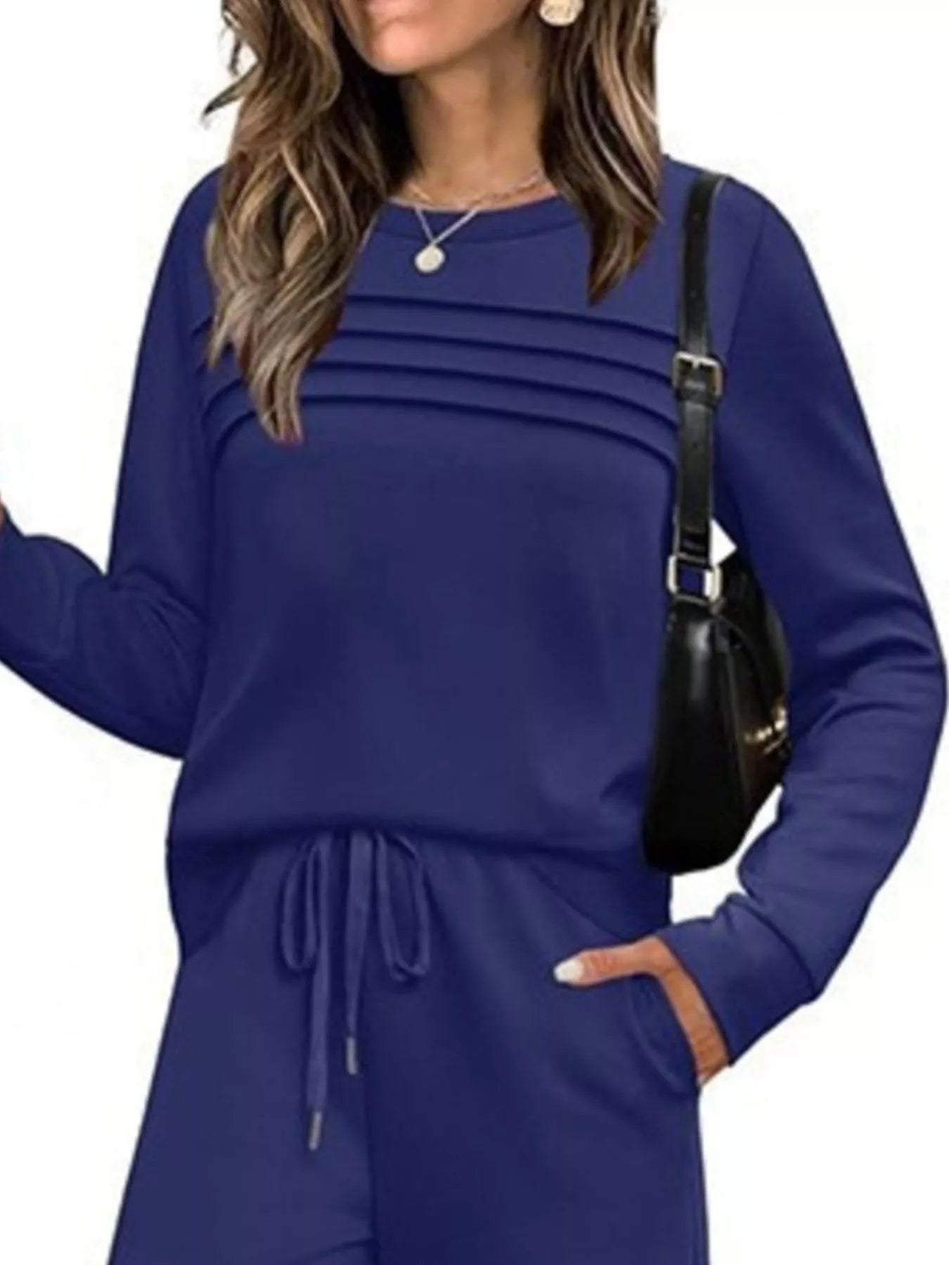 NEWYORKLISTED COMFORT COLLECTION: Woman wearing a blue outfit with a black handbag on a white background