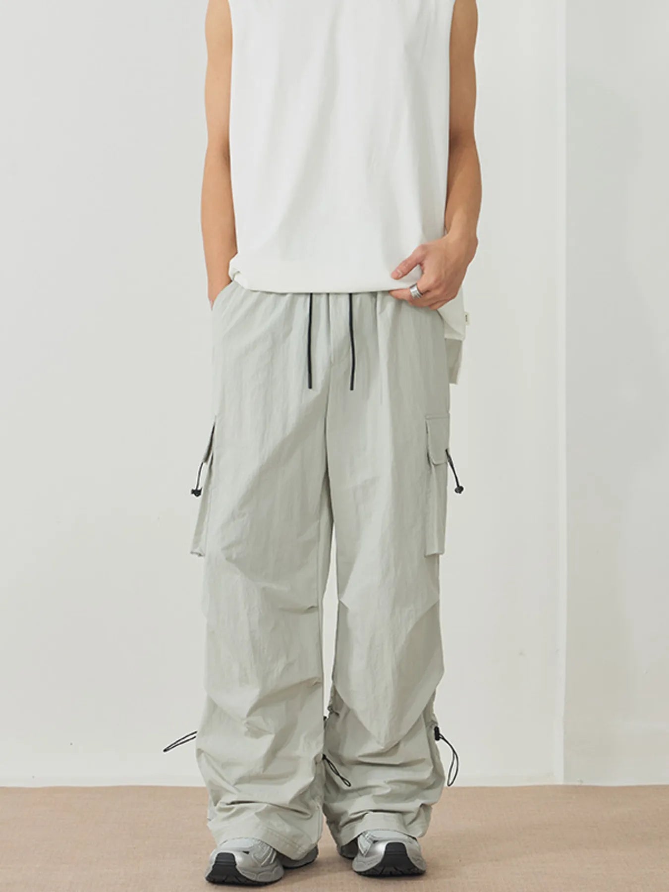 NEWYORKLISTED ATLAS MEN's Collection: Person wearing light gray cargo pants and a white sleeveless top on a plain background