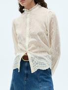 NEWYORKLISTED STYLE COLLECTION: White lace blouse over a blue denim shirt on a white background