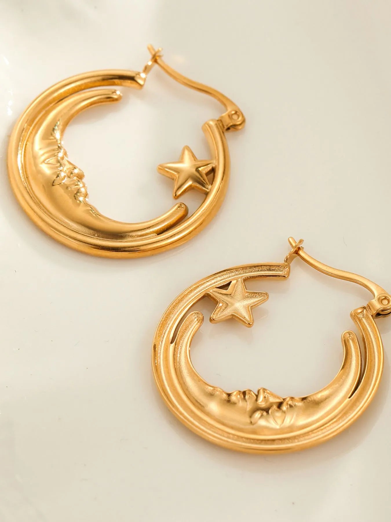 Gold hoop earrings with star and crescent moon designs on a light background: NEWYORKLISTED STYLE COLLECTION 