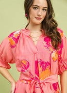 NEWYORKLISTED STYLE COLLECTION: Woman wearing a pink floral dress with a green background
