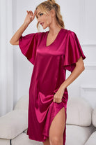 NEWYORKLISTED Intimate Apparel: Woman wearing a pink satin nightgown sitting on a white couch.