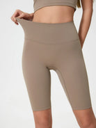Beige high-waisted shorts being modeled on a plain background