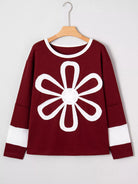 NEWYORKLISTED STYLE COLLECTION: Maroon sweater with a white flower design on a hanger against a white background