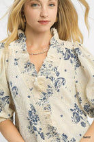 NEWYORKLISTED STYLE COLLECTION: Woman wearing a cream-colored blouse with blue floral patterns on a white background