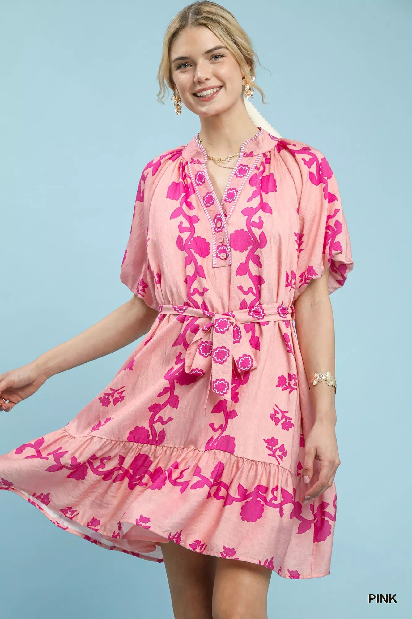NEWYORKLISTED STYLE COLLECTION: Woman wearing a pink floral dress against a light blue background