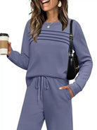 NEWYORKLISTED COMFORT COLLECTION: Woman wearing a blue outfit holding a coffee cup and black handbag on a white background