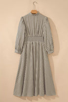 NEWYORKLISTED STYLE COLLECTION: Striped dress on a hanger against a beige background