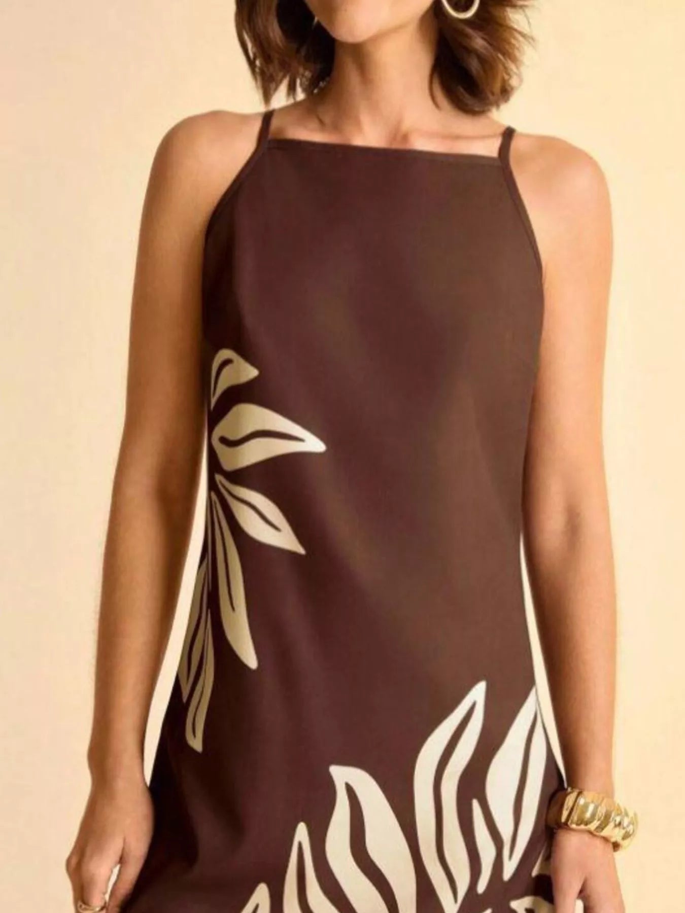 NEWYORKLISTED STYLE COLLECTION: Brown dress with white leaf patterns worn by a person on a beige background