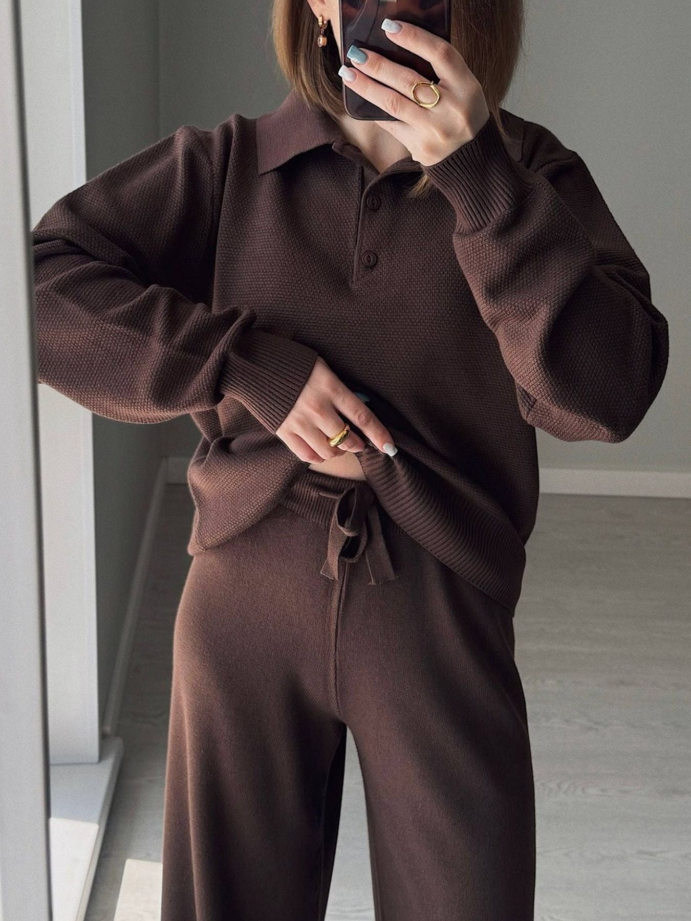 NEWYORKLISTED Comfort Collection: Person wearing a brown knit outfit taking a mirror selfie.