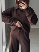 NEWYORKLISTED Comfort Collection: Person wearing a brown knit outfit taking a mirror selfie.