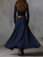 NEWYORKLISTED Style Collection: Person wearing a long navy dress with a belt and brown boots against a gray background