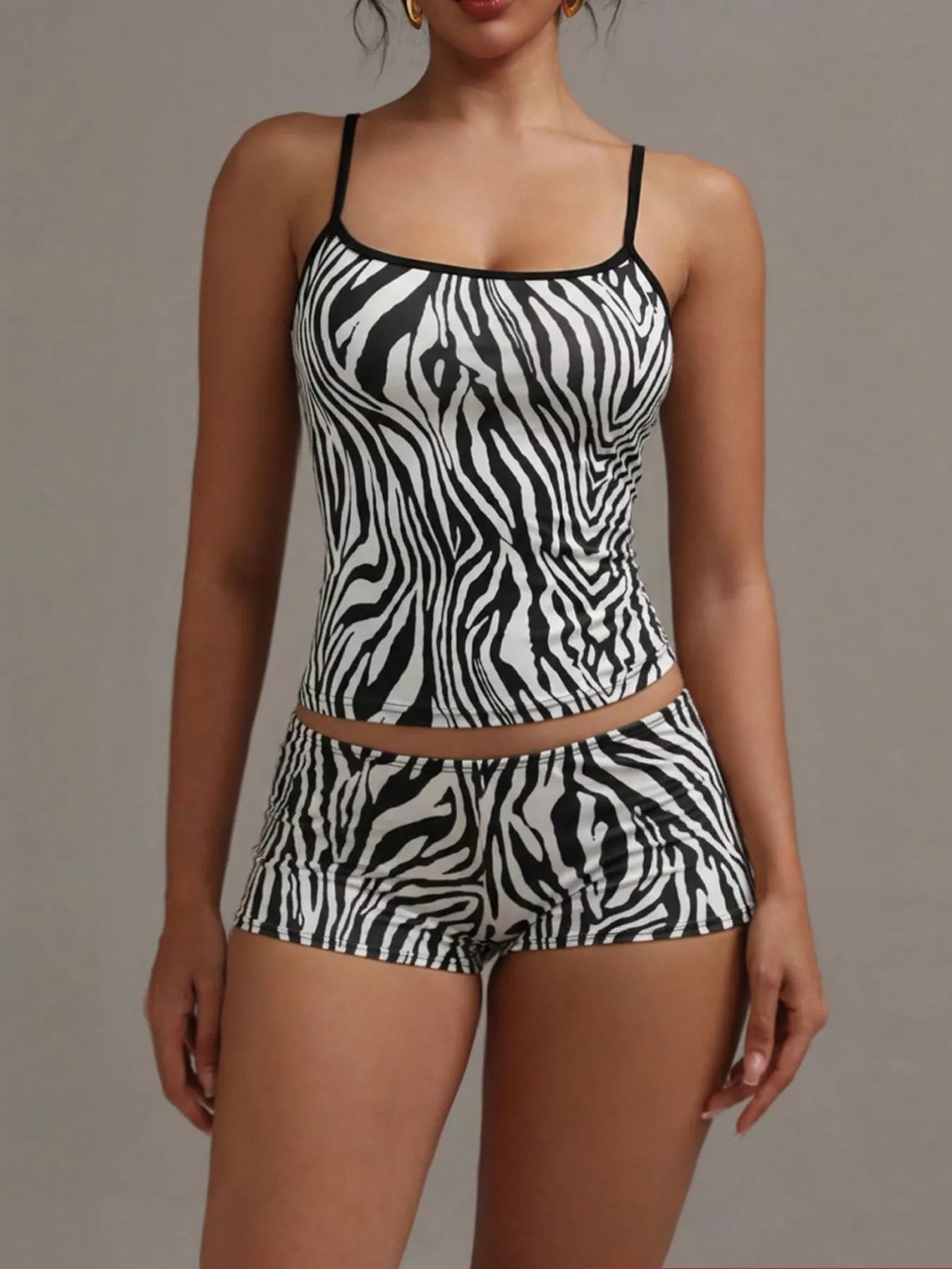 NEWYORKLISTED INTIMATE APPAREL COLLECTION: Woman wearing a zebra print swimsuit against a neutral background