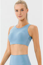 NEWYORKLISTED ACTIVEWEAR COLLECTION: Woman wearing a light blue sports bra and leggings on a white background
