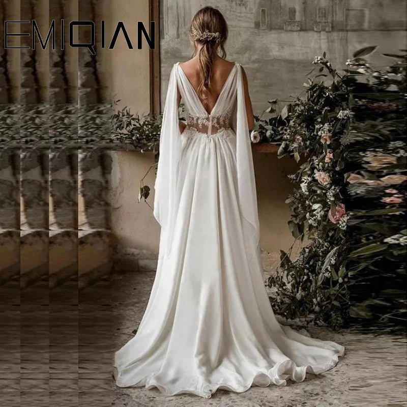 Woman in a white wedding dress with a floral arch and mirror reflection in the background