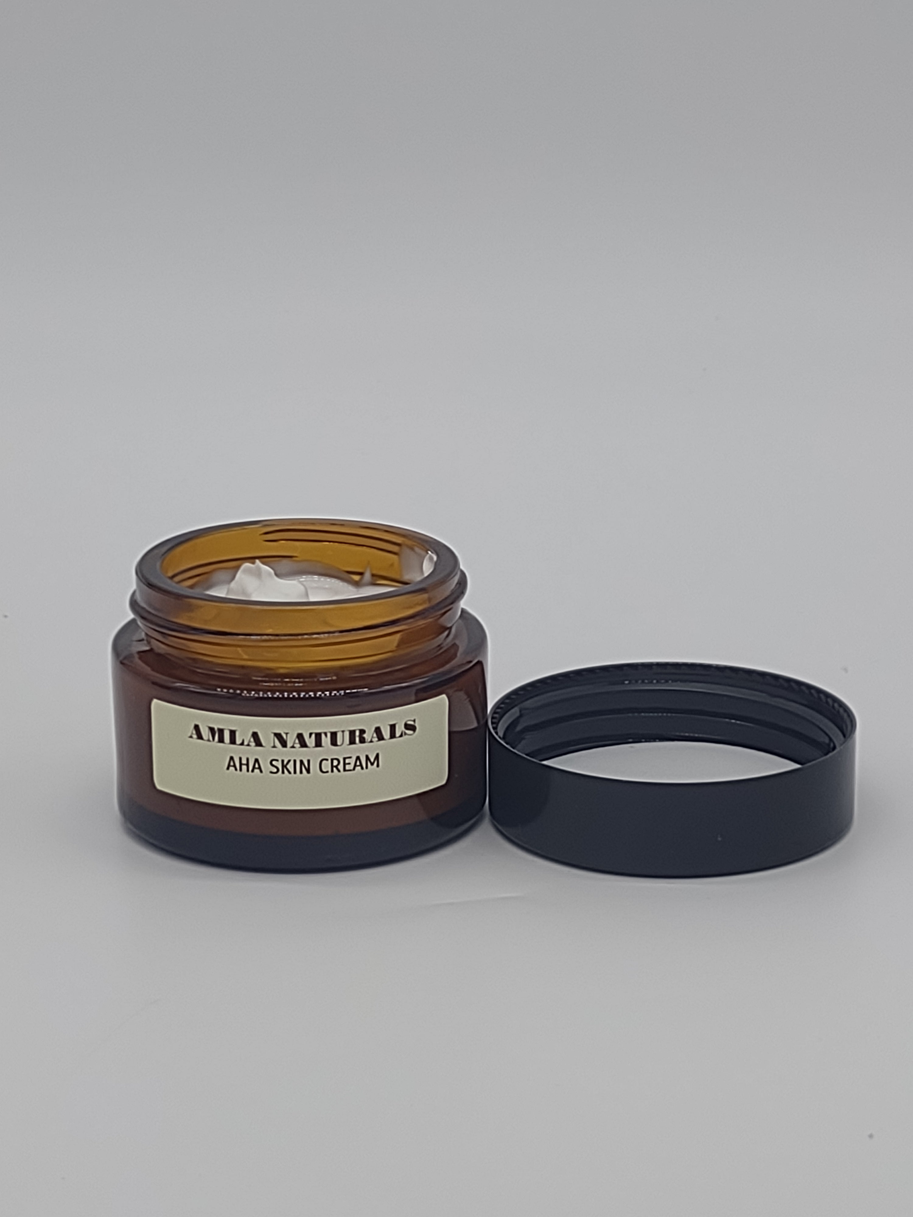AMLA NATURALS AHA Skin Cream: Jar of AHA skin cream with a black lid on a light gray background