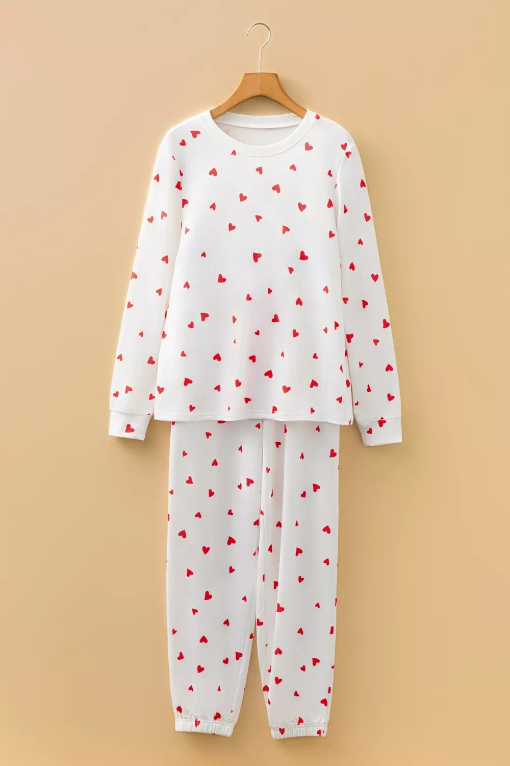 NEWYORKLISTED Intimate Apparel Collection: White pajama set with red heart patterns on a beige background