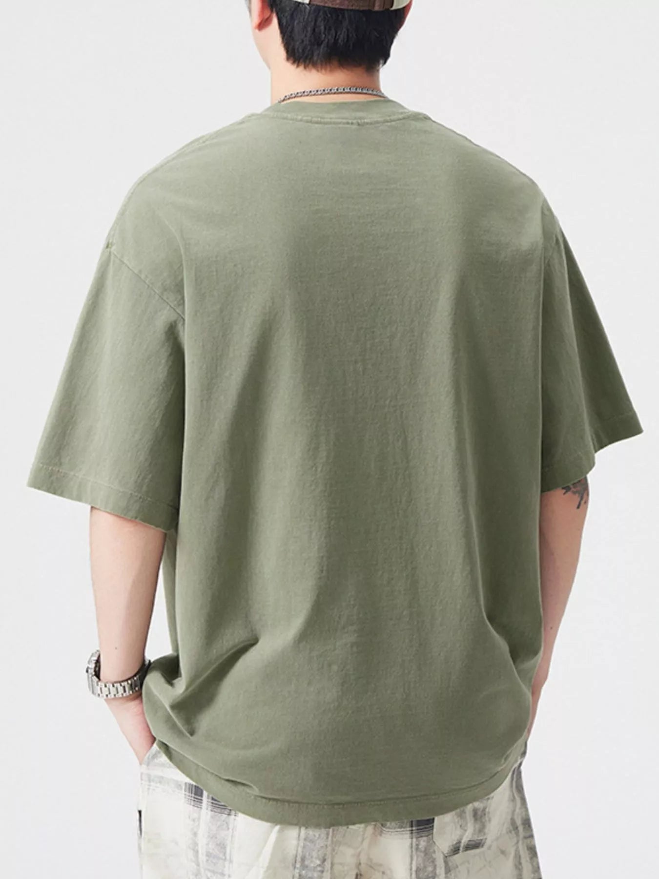 NEWYORKLISTED ATLAS MEN's COLLECTION: Person wearing a green t-shirt on a white background