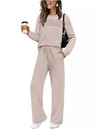 NEWYORKLISTED COMFORT COLLECTION: Woman wearing a beige lounge set holding a coffee cup on a white background