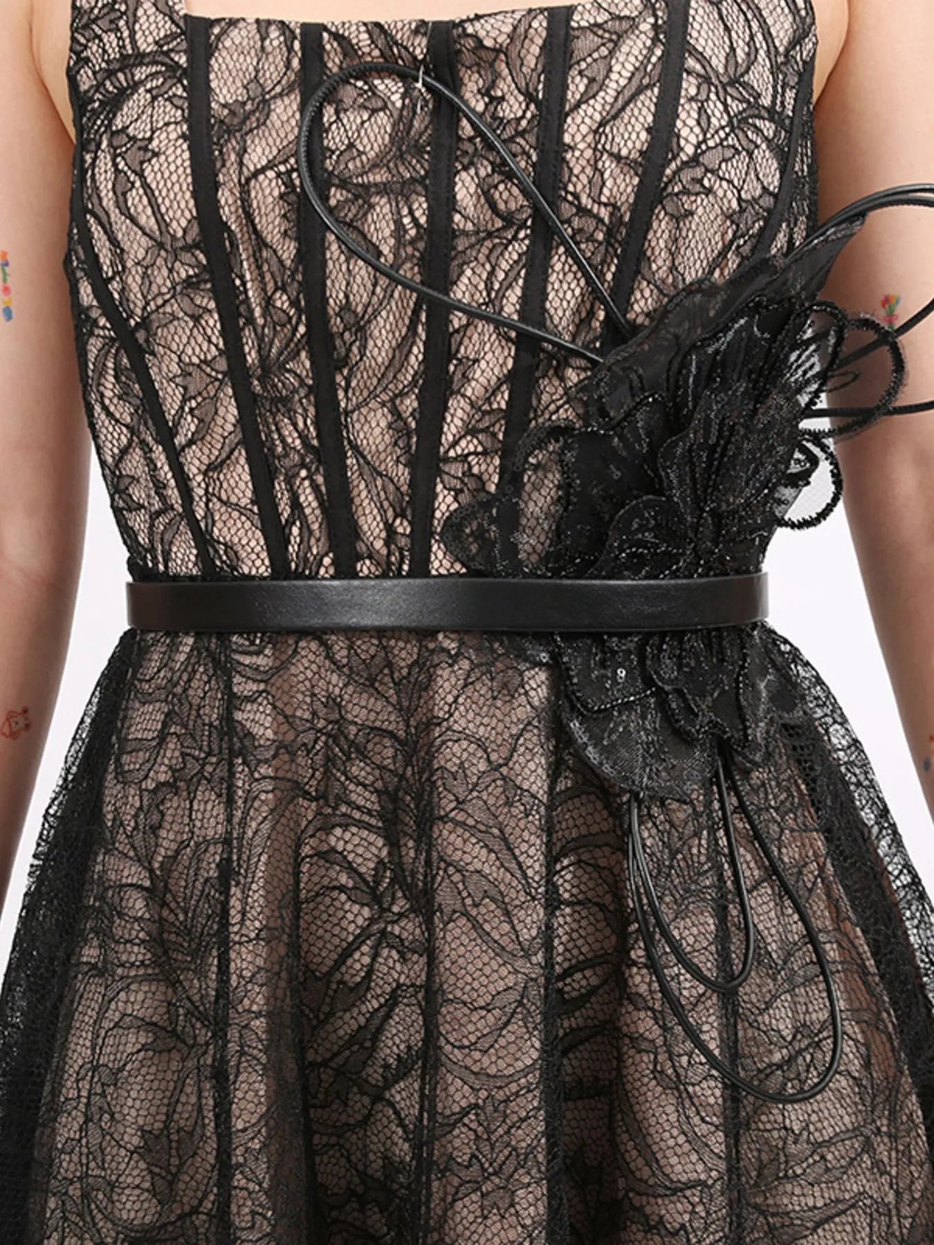 NEWYORKLISTED RUNWAY STYLE: Black lace dress with floral details and a belt on a white background