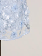 NEWYORKLISTED STYLE COLLECTION: Close-up of a light blue floral dress on a mannequin against a beige background