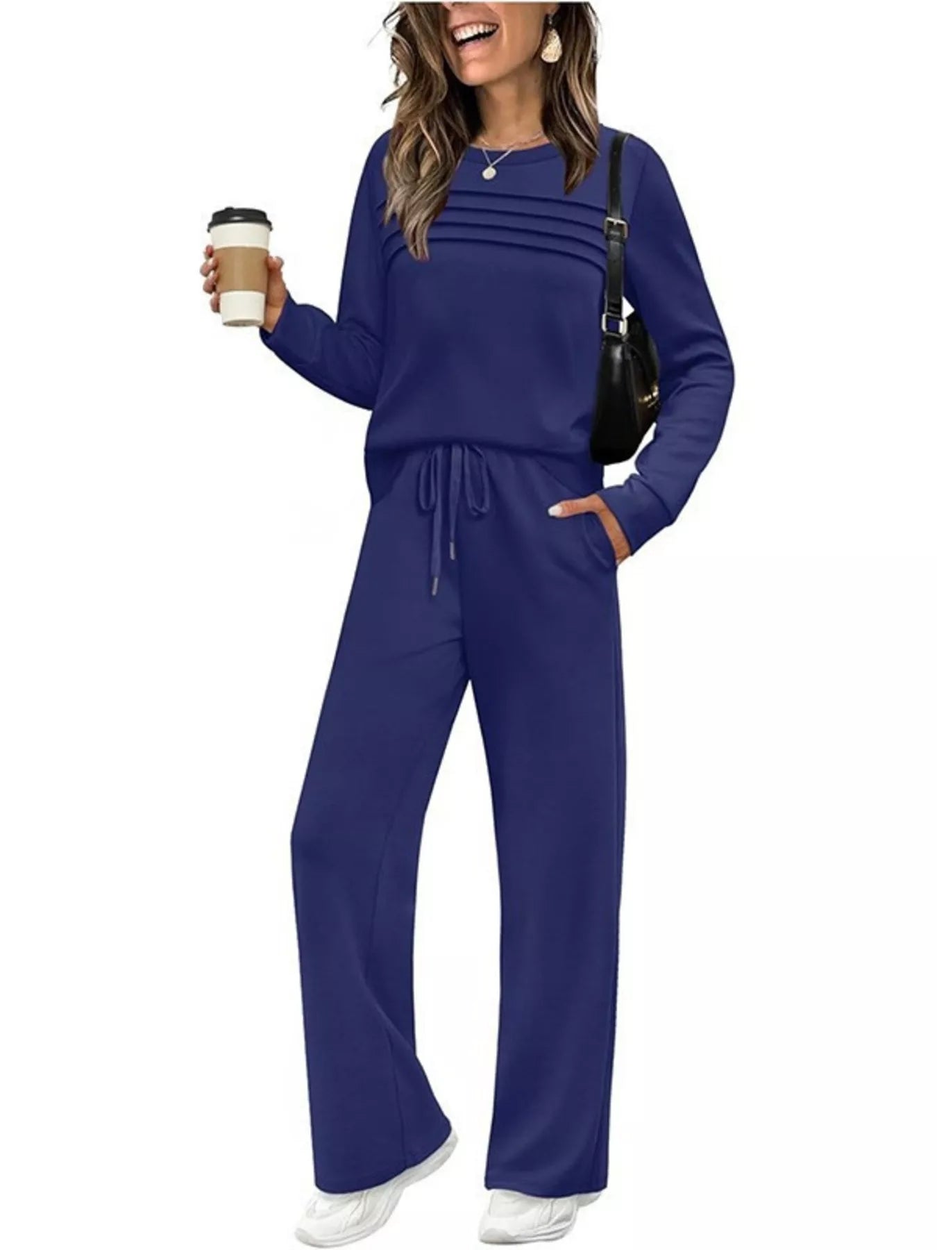 NEWYORKLISTED COMFORT COLLECTION: Woman wearing a blue outfit holding a coffee cup on a white background