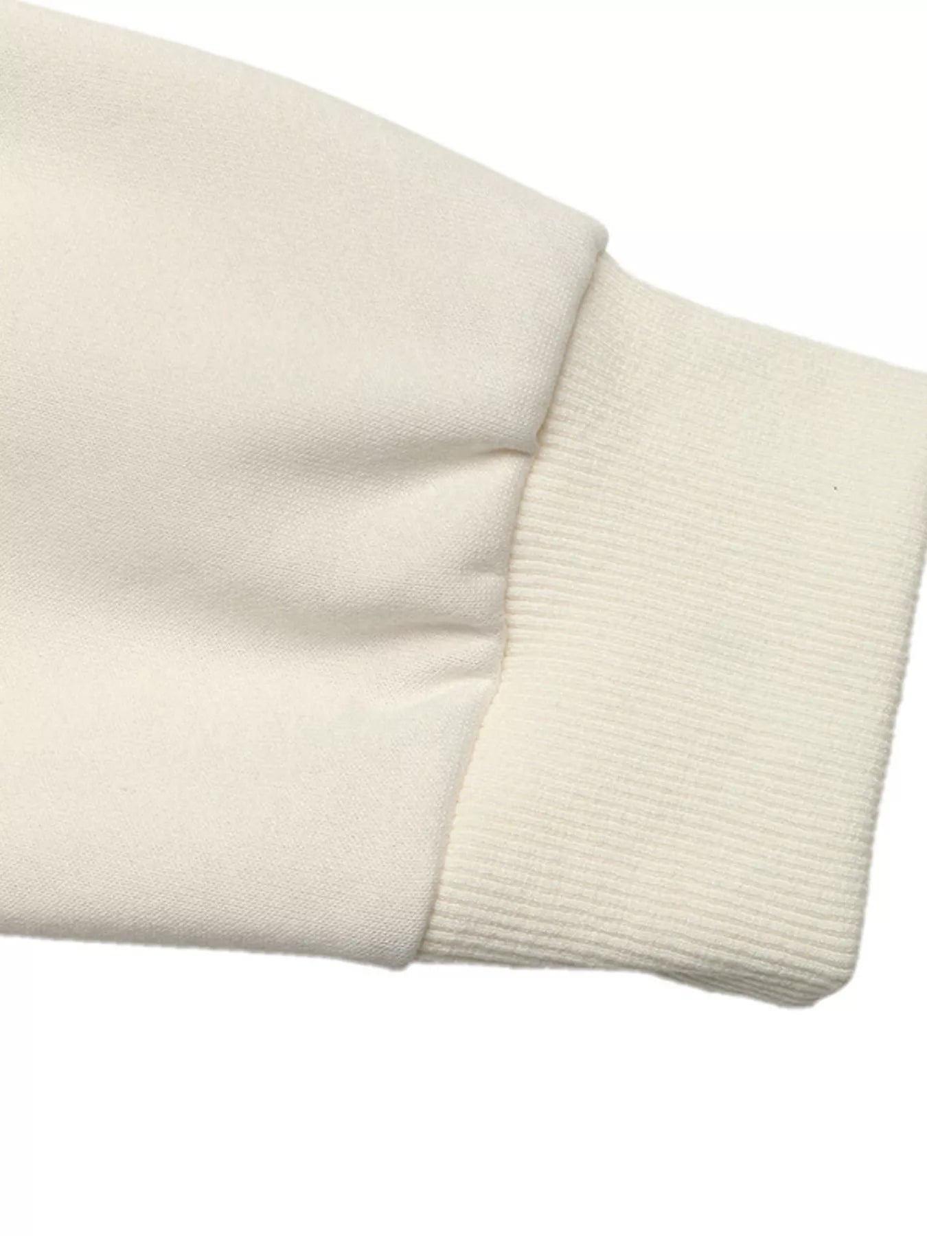 NEWYORKLISTED STYLE COLLECTION: Close-up of a beige sweater sleeve on a white background