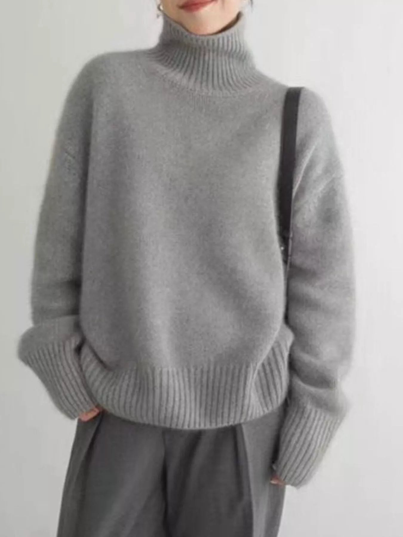 NEWYORKLISTED STYLE COLLECTION: Person wearing a gray turtleneck sweater and pants on a plain background