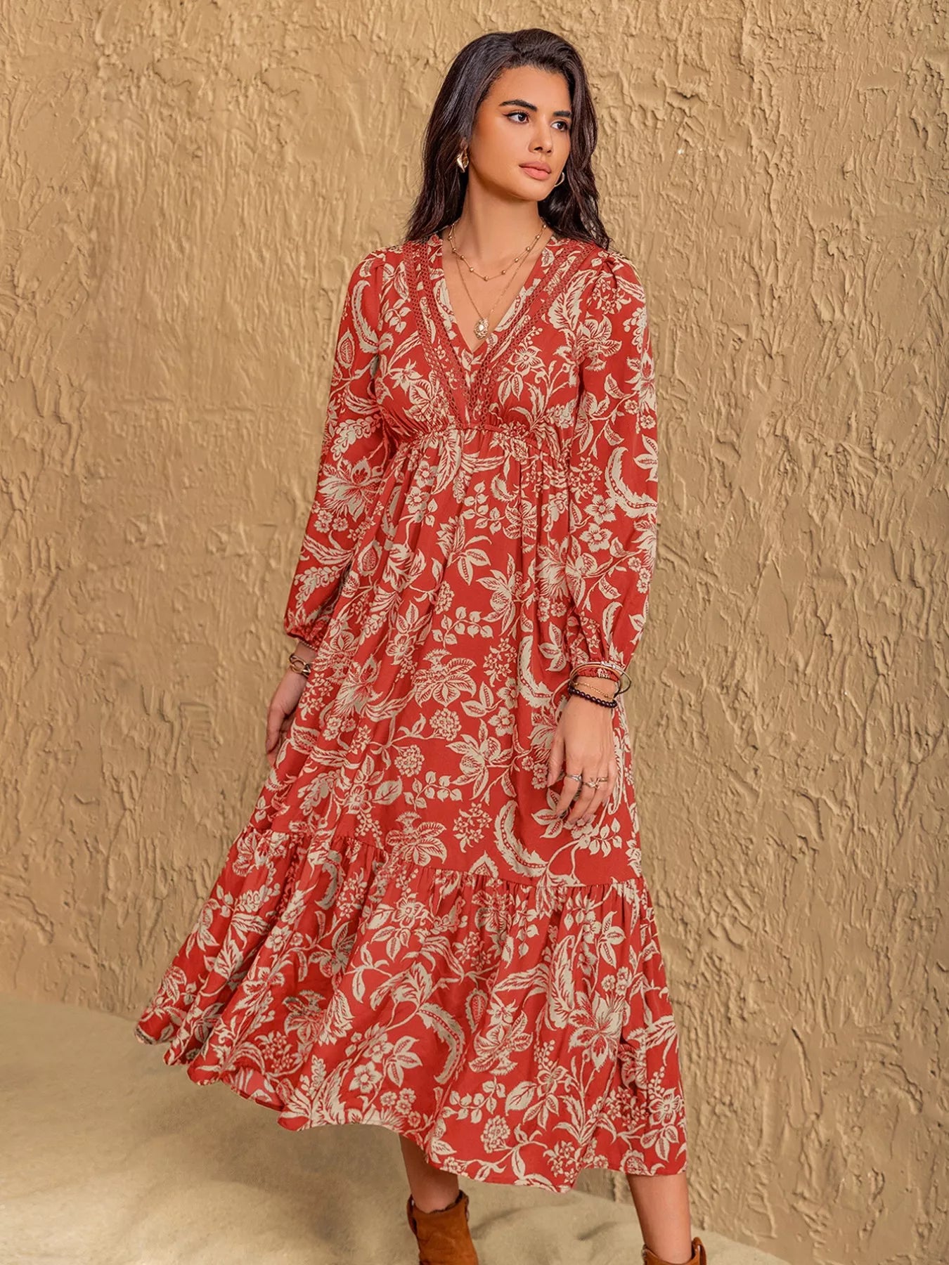 NEWYORKLISTED STYLE COLLECTION: Woman wearing a red floral dress against a beige wall