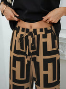 NEWYORKLISTED: Person wearing black and beige patterned pants with a white background