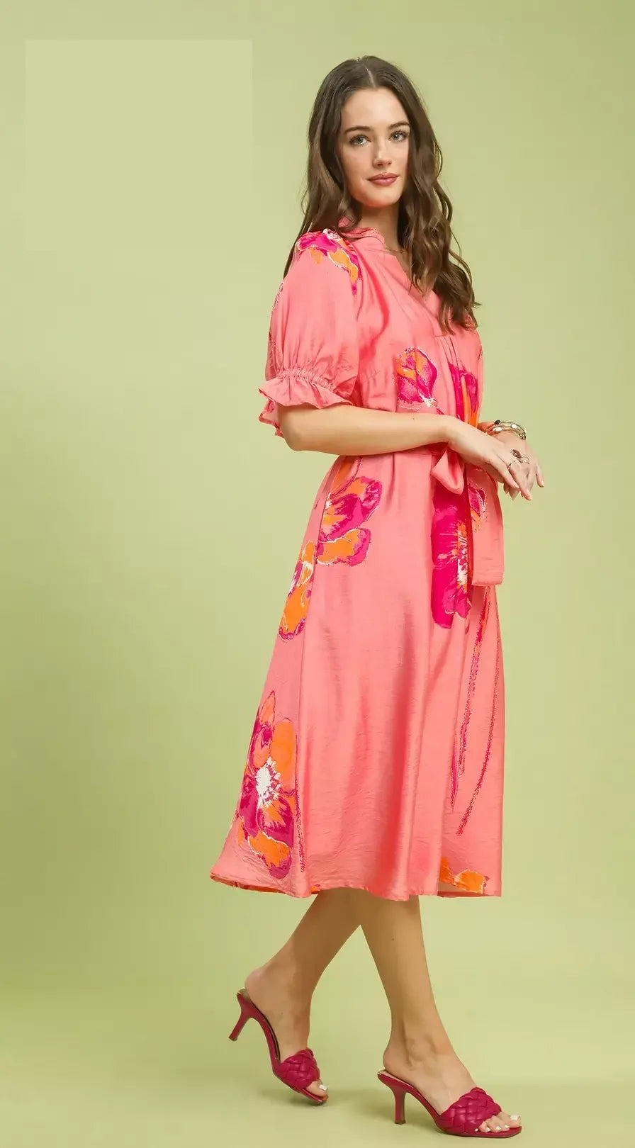 NEWYORKLISTED STYLE COLLECTION: Woman wearing a pink dress with floral patterns on a light green background
