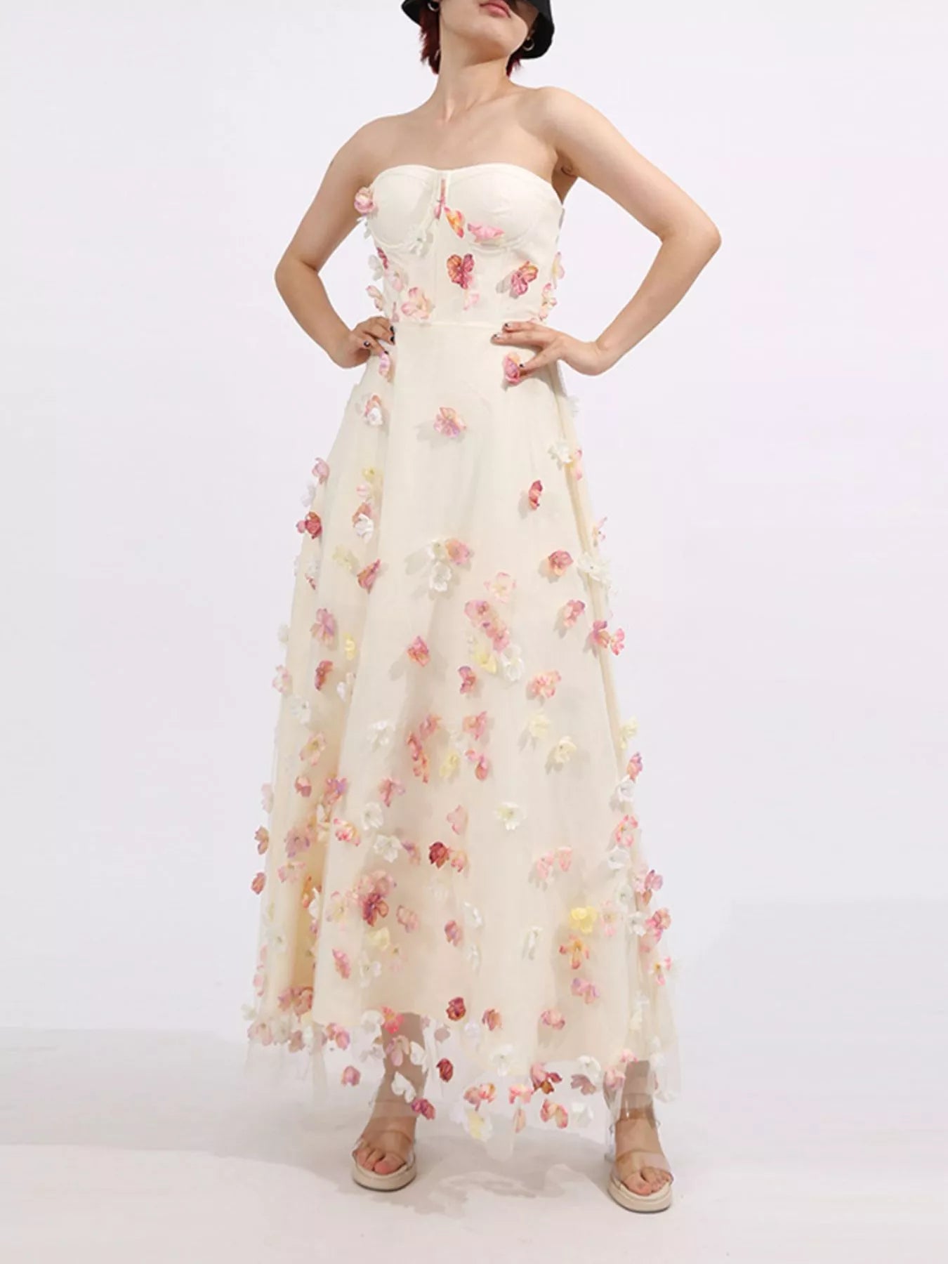 NEWYORKLISTED STYLE COLLECTION: Woman wearing a strapless floral gown on a white background