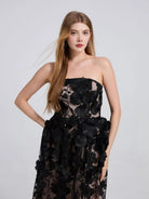 NEWYORKLISTED STYLE COLLECTION: Woman wearing a black floral strapless dress on a light gray background