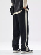 NEWYORKLISTED ATLAS MEN's COLLECTION: Person wearing black pants with white stripes on a white background