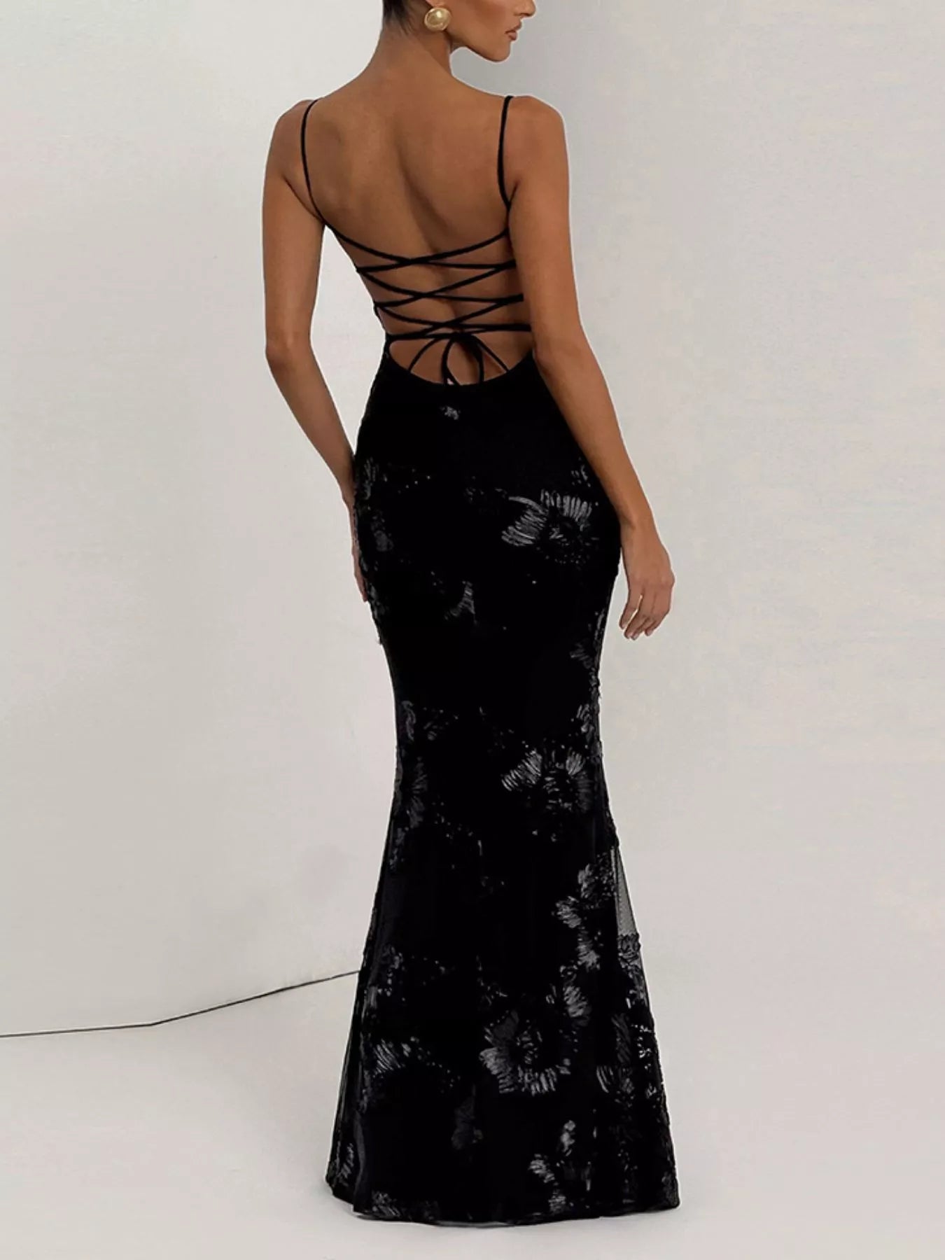 NEWYORKLISTED STYLE COLLECTION: Black evening gown with lace-up back on a white background
