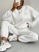 NEWYORKLISTED COMFORT COLLECTION: Person wearing a white cable knit tracksuit with sneakers on a gray background