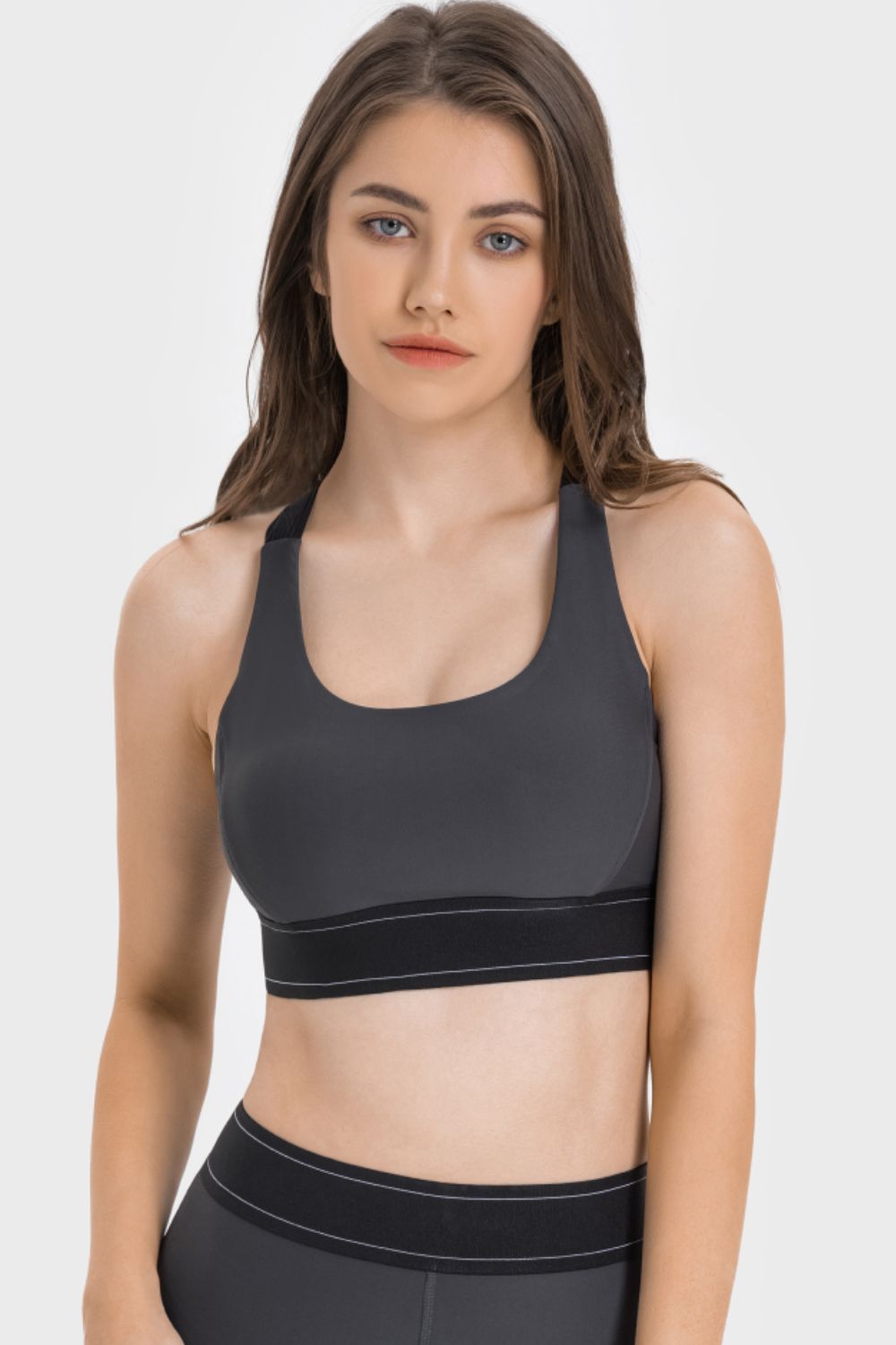 NEWYORKLISTED ACTIVEWEAR COLLECTION: Woman wearing a black sports bra and leggings on a white background